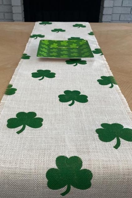 Table runner wih clover pattern under a square green plate