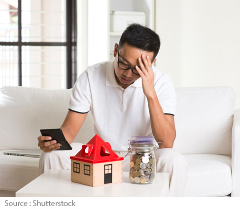 Homme assis devant maison et bocal d'argent
